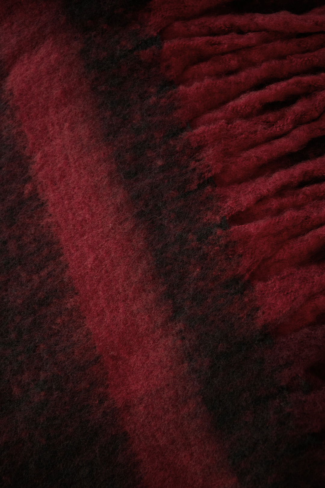 Close-up of a red and dark-toned patterned Babe scarf with a soft textured finish from Sorea Fashion.
