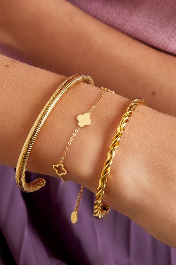 Gold Clover bracelet featuring small clover charms worn stacked with another bracelet from Sorea Fashion.